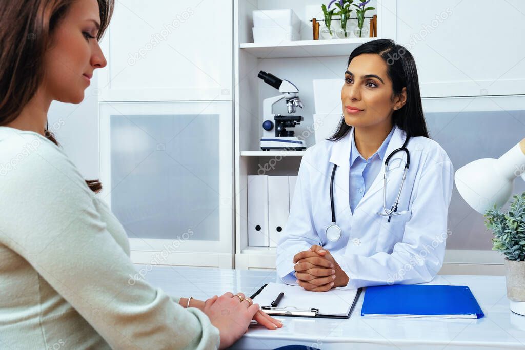 Young lady client patient visiting pleasant attentive female doctor physician at modern clinic medical center