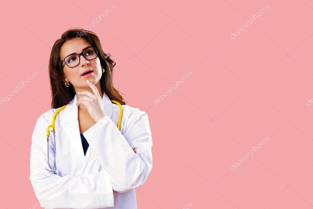 Portrait of beautiful female doctor in glasses thinking and looking upwards