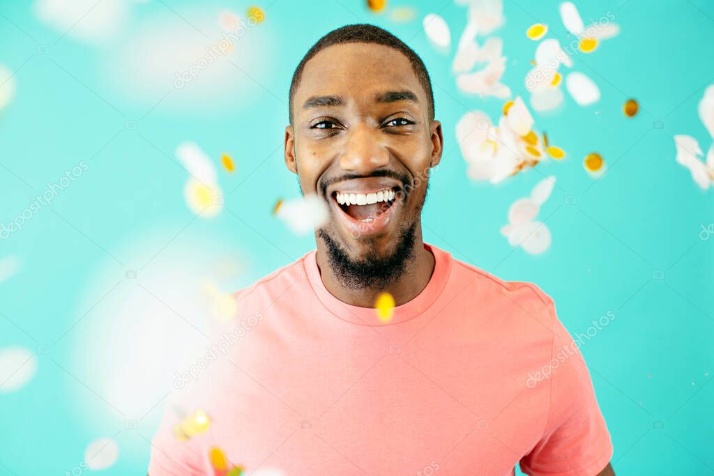 portrait of a cheerful African American throwing confetti