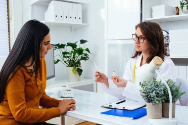 Corona virüsü aşısını ve şırıngayı elinde tutan kadın doktor COVID-19 enfeksiyonunu önlemek için kullanıyor.