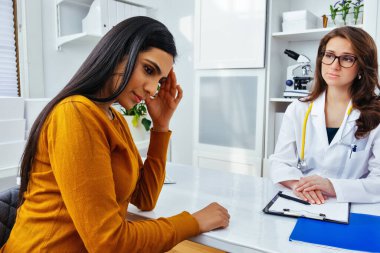 Kadın doktor hastanede üzgün bir hastayla konuşuyor.