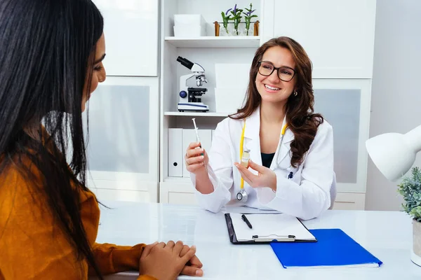 Corona virüsü aşısını ve şırıngayı elinde tutan kadın doktor COVID-19 enfeksiyonunu önlemek için kullanıyor.