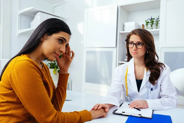 Kadın doktor hastasıyla hastanede konuşuyor.