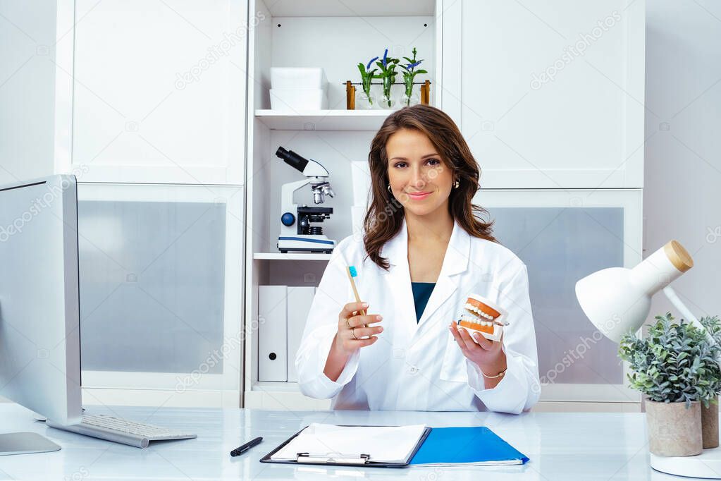 smiling female doctor showing human jaws and teeth mockup 