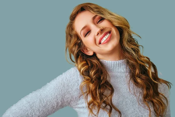 Uzun kıvırcık saçlı, gülümseyen güzel bir kadının portresi. 