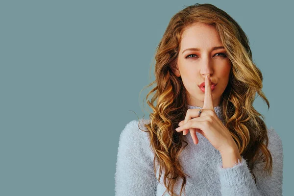 Uzun kıvırcık saçlı, süveter giyen güzel bir genç kadının portresi. 