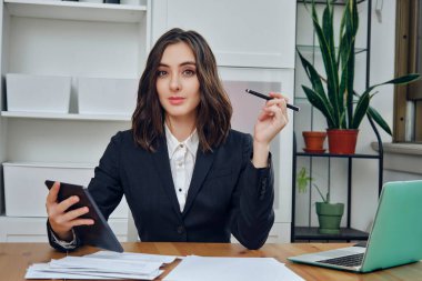 Laptop ve belgelerle çalışan genç iş kadını. 