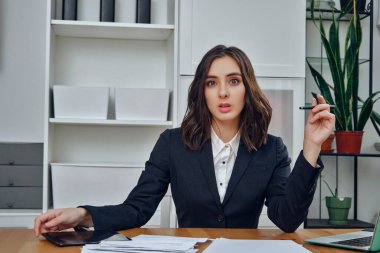 Laptop ve belgelerle çalışan genç iş kadını. 