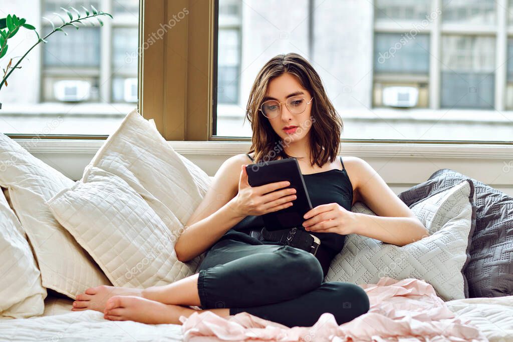 young beautiful woman with tablet pc on sofa at home