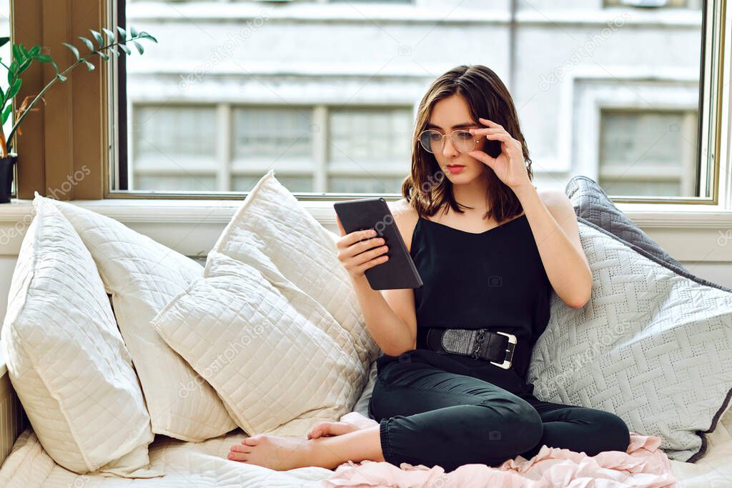 young beautiful woman with tablet pc on sofa at home