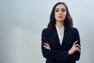 Beyaz arka planda siyah ceket giyen güzel bir iş kadınının portresi.