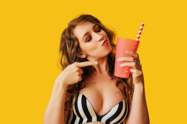 Renkli arka planda kokteyli olan güzel genç bir kadın.