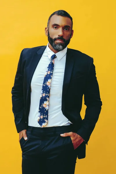スーツ姿のハンサムな髭を生やした男の肖像画と黄色の背景の上に孤立して立っているネクタイカメラを見て — ストック写真