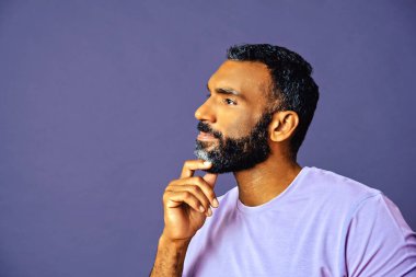 Mavi arka planda sakallı ve bıyıklı bir adamın portresi.