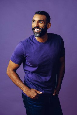 Mor arka planda sakallı ve bıyıklı yakışıklı bir Afro-Amerikan 'ın portresi.