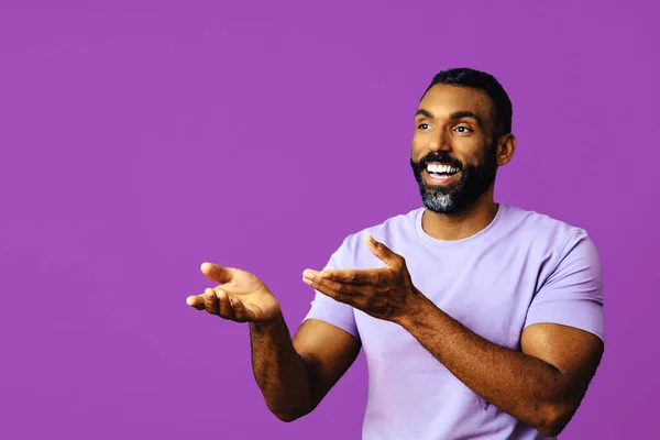 ひげと髭を生やした若いアフリカ系アメリカ人男性がピンクの背景をカメラで見て笑っています — ストック写真