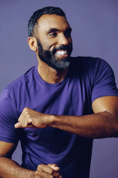 Gri arka planda sakallı ve bıyıklı yakışıklı bir gencin portresi.