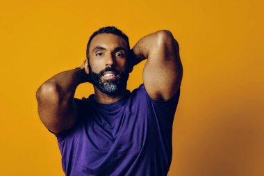 Sarı arka planda sakallı ve bıyıklı yakışıklı bir gencin portresi.