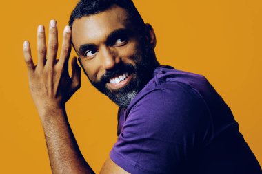 Siyah takım elbiseli ve pembe tişörtlü, afro saçlı yakışıklı bir gencin portresi.