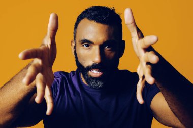 Gri arka planda sakallı ve bıyıklı yakışıklı bir gencin portresi.