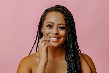 Pembe arka planda güzel bir Afrikalı Amerikalı kadının portresi.