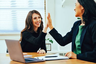 High five businesswoman smiling sitting at modern office small business
