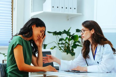 young female doctor explaining treatment to worried woman patient at health checkup
