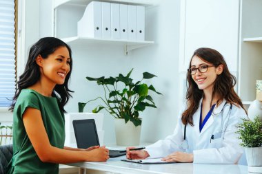 young female doctor smiling with woman patient consultation clinic health checkup