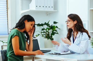 young female doctor explaining treatment to worried woman patient at health checkup