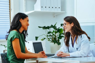 Female doctor and patient smiling consultation clinic health checkup treatment