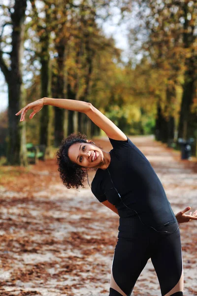 positive middle age woman stretching outdoors preparing for exercise in sportswear