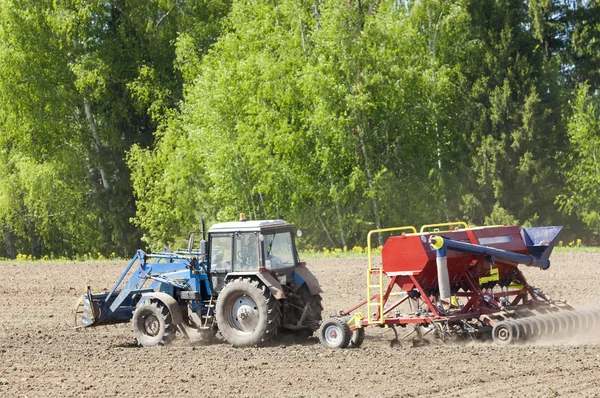 Landbouwwerkzaamheden ploegen land op een krachtige trekker — Stockfoto