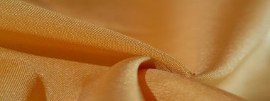 Sarı renkli ipek kumaş. Renkli ipek kumaşın dokusu arka plan olarak kullanılabilir