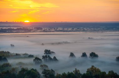 Nehir ovasında sonbahar. Sis, vadileri ve tepeleri aydınlık ve güneşli tutarken, yukarıdan bakıldığında, sis muhteşem olabilir..