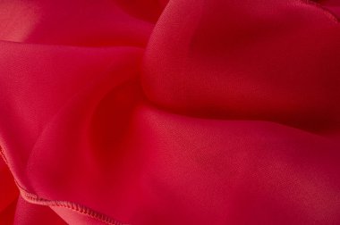 Kırmızı ipek katlanmış kumaş arka plan, afiş veya kapak tasarımı. Poster için lüks tekstil dekorasyonu yumuşak saten dalgalı kırmızı kumaş, poster dokusu. Geçmişi. Desen.