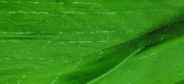 Yeşil ipek kumaş ve lurex. Parlak doku arka plan, saten arka plan, lüks kumaş, zarif desen, renkli soyut, renkli kadife, parçalanmış makro.