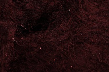 Bordo renkli kırmızı ipek kumaş. Kumaşın yüzeyinde pullar ve iplikler var. Bu kırmızı tül, soyut işlemelerle süslenmiş, pullarla ve Avrupalı bir tasarımcının iplikleriyle süslenmiş.