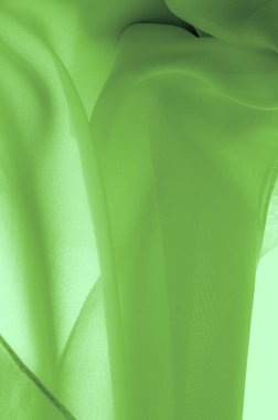 Açık yeşil ipek polyester. Kireç yeşili ipek kumaştan. Şeffaf arkaplan ve elbise dikmek için açık kumaştan yapılmış. Tekstil panoraması