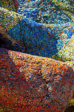 Eski mozaik. Beton bir yüzeyde çok renkli cam parçaları. Taş, kiremit ya da cam gibi sert bir maddenin küçük renkli parçalarını birleştirerek elde edilen bir desen..