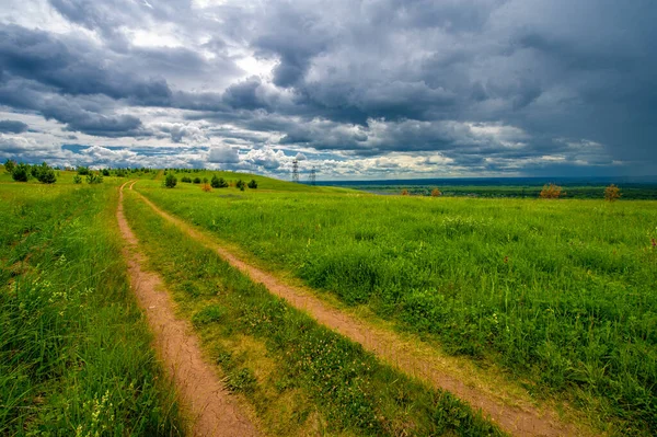 Yaz manzarası, büyük bir nehir, nehrin kıyısında çayır çiçekleri, gökyüzünde güçlü bulutlar, Kama Nehri boyunca bir turist yürüyüşü.