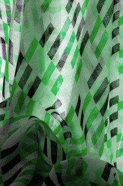 Yeşil ve siyah geometrik eşkenar dörtgen şekilli beyaz ipek kumaş. Soyut çizim frangı, yakın plan, tasarım için arka plan, klasik parlak desen. Doku. Geçmişi. Şablon.