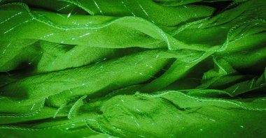 Yeşil ipek kumaş ve lurex. Parlak doku arka plan, saten arka plan, lüks kumaş, zarif desen, renkli soyut, renkli kadife, parçalanmış makro.