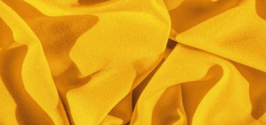 Sarı ipek. Pürüzsüz, zarif, sarı, lüks ipek kumaş kopya alanı olan soyut bir arkaplan olarak kullanılabilir. Renkli doku