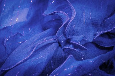 Lurex 'li mavi ipek kumaş. Parlak doku arka plan, saten arka plan, lüks kumaş, zarif desen, renkli soyut, renkli kadife, parçalanmış makro.