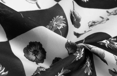 İpek kumaş. Çiçek desenli siyah beyaz kareler. Çiçekler siyah ve beyaz. Doku arkaplan modeli. Çiçek izinden, kumaş ilkbaharda soluyor ve keyfi yerinde..