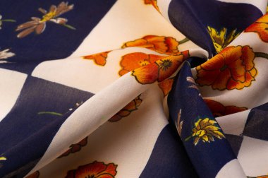 İpek kumaş. Çiçek desenli beyaz ve mavi kareler. Çiçekler kırmızı-sarı. Çiçek izinden, kumaş ilkbaharda soluyor ve keyfi yerinde..