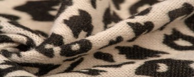 Doku, arkaplan, desen, kadın yün şalı, siyah ve bej, Afrika motifleri, yün ve modülden yapılmış, kenarları kıvrımlı bir yılan şeklinde..