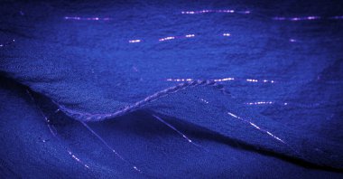 Lurex 'li mavi ipek kumaş. Parlak doku arka plan, saten arka plan, lüks kumaş, zarif desen, renkli soyut, renkli kadife, parçalanmış makro.