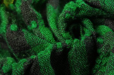 Doku, arka plan, desen bir insanın boynuna takılacak yün bir eşarp. Atkıda yeşil siyah renk