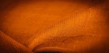 Kahverengi ve sarı kumaş, koyu kehribar ipeği, parlak güneşli soyut arkaplan çizimi. Dekoratif eşyalar yakın plan. Duvar kağıdı dokusu, arkaplan